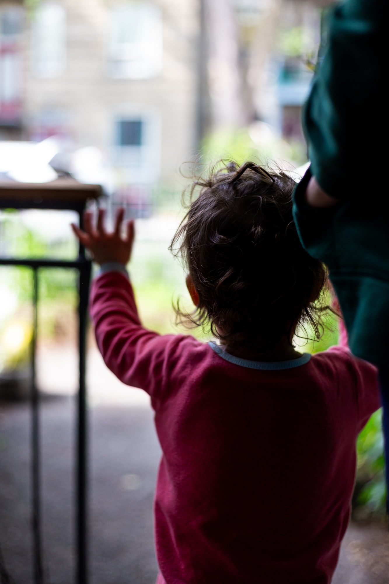 Petite fille de dos faisant au revoir de la main