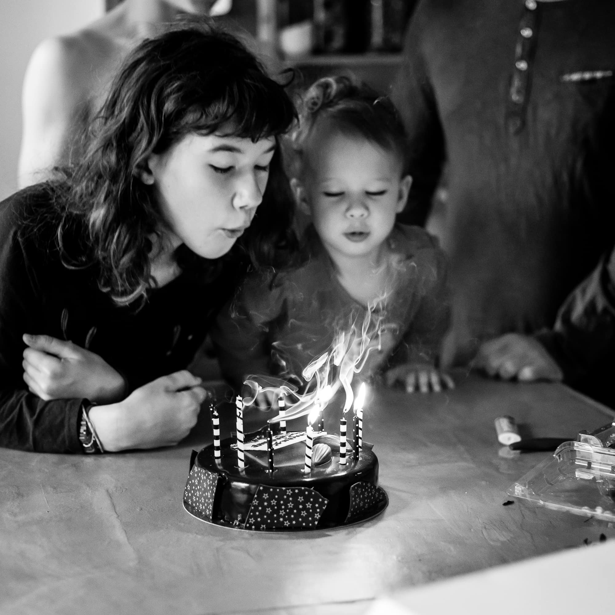 Grande et petite soeur soufflant des bougies de gateau