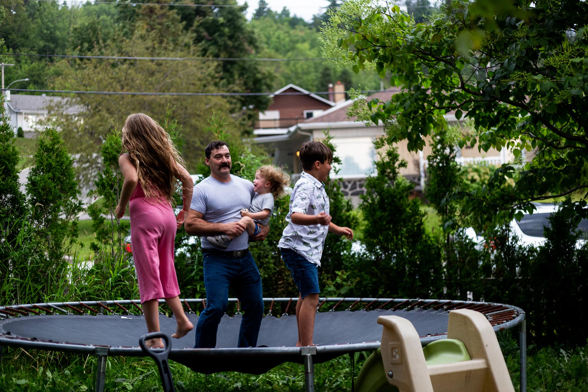 Père et 3 enfants dans le trempoline