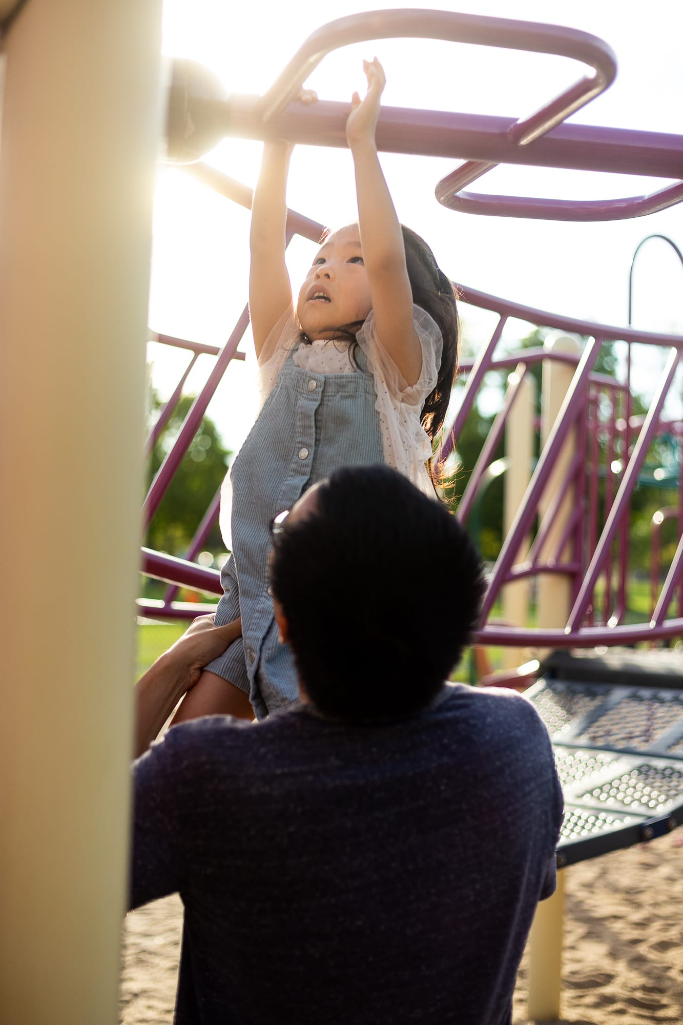 père aidant sa fille dans les monkey bars